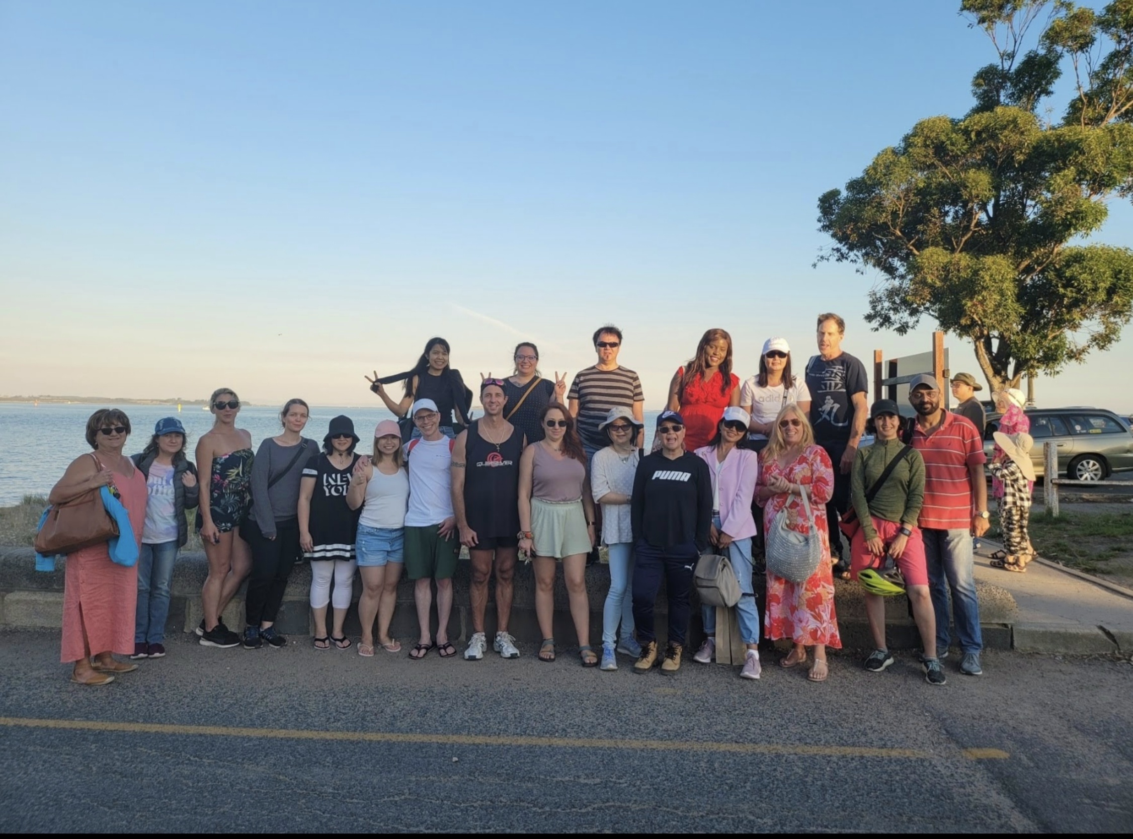 Community group gathered outdoors beside the waterfront before MANZU